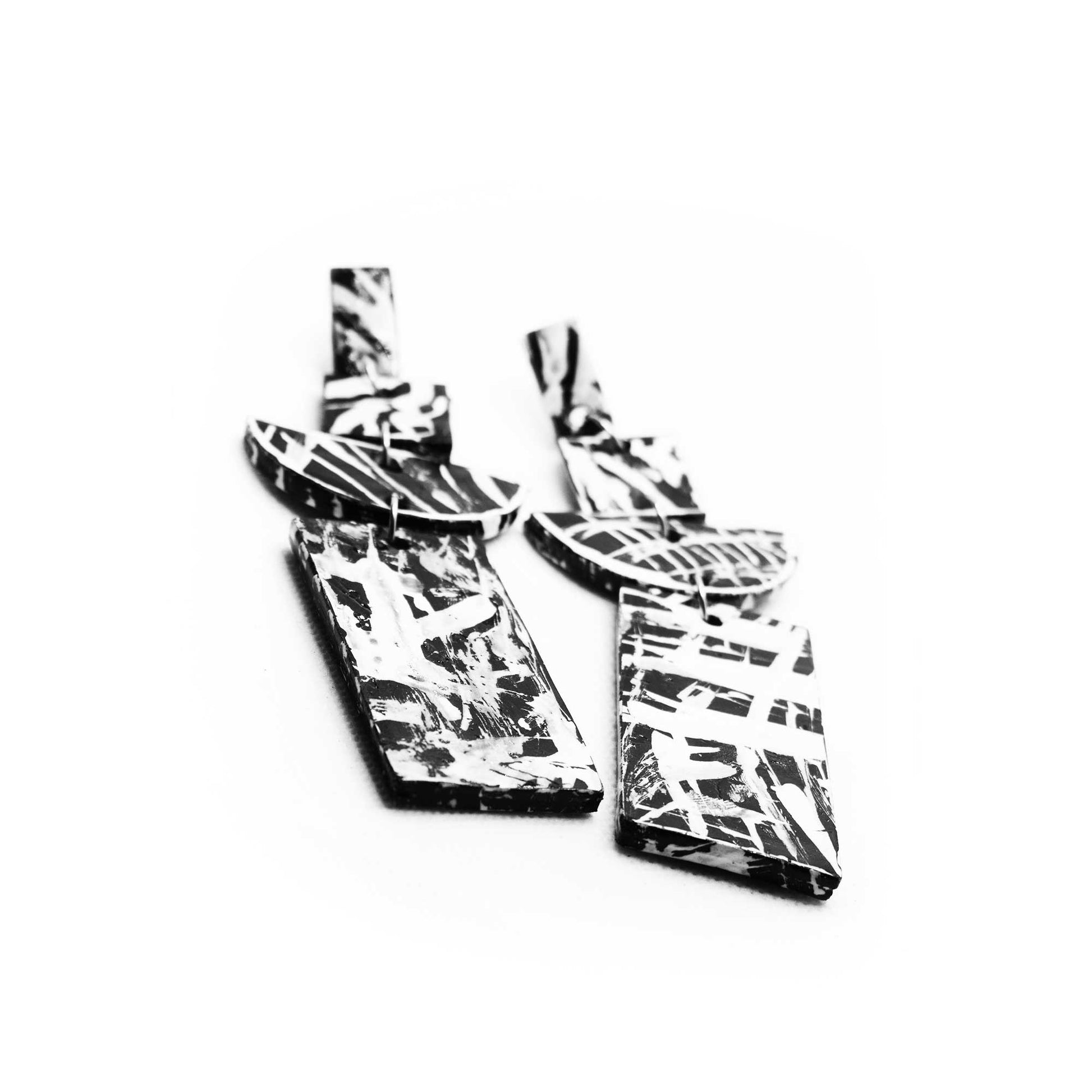 Boucles d'oreilles en liège peint à la main, design précis et géométrique, contrastes noirs et blancs