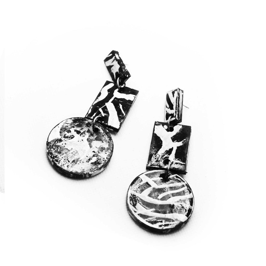 Boucles d'oreilles en liège peint à la main, motifs linéaires noirs et blancs, style minimaliste et contemporain